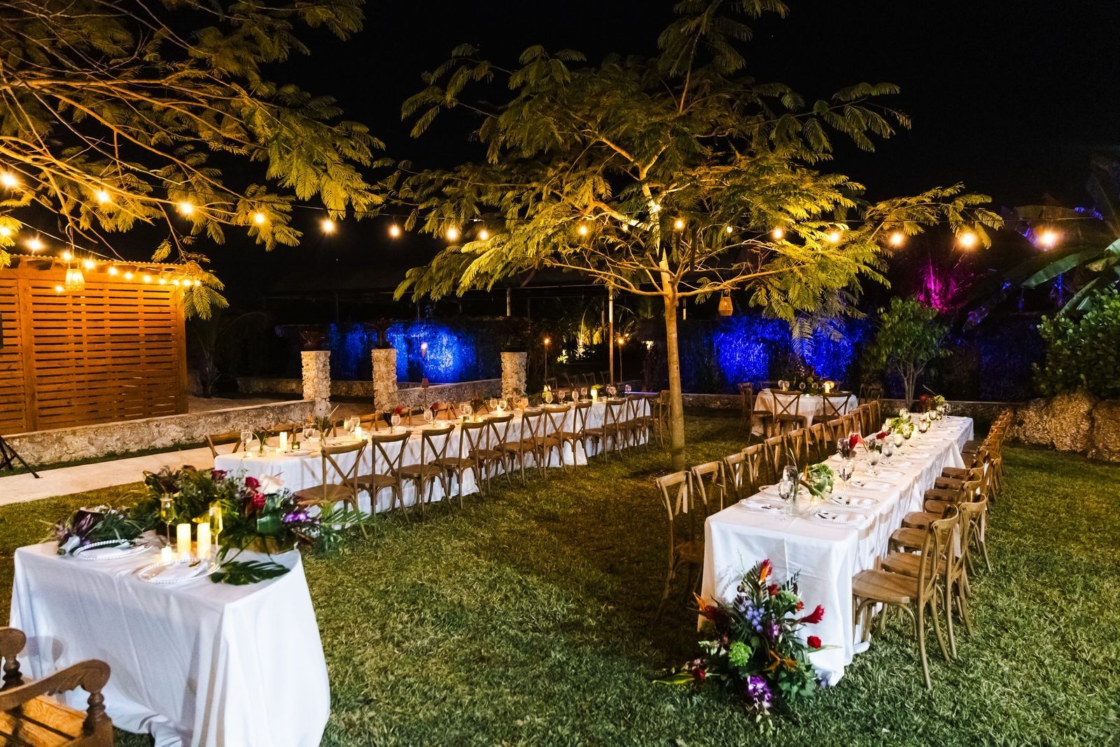 Reception tables set under string lights at night