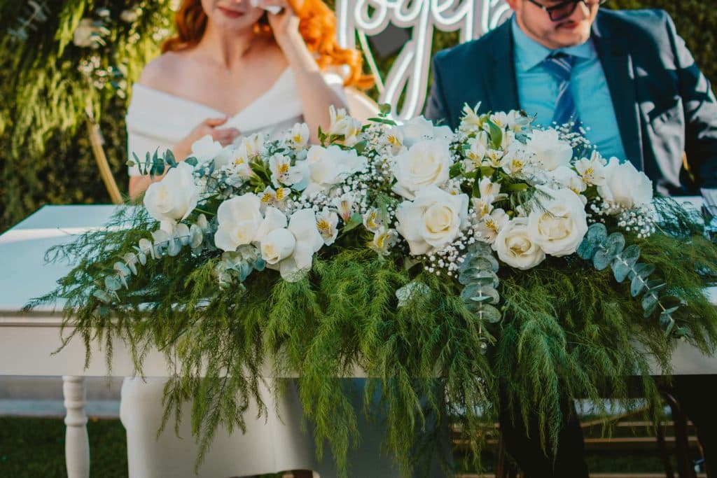 Is WeddingWire Worth It? A Guide for Wedding Venues 3 A close up of the bride and groom table with a large white floral arrangement.