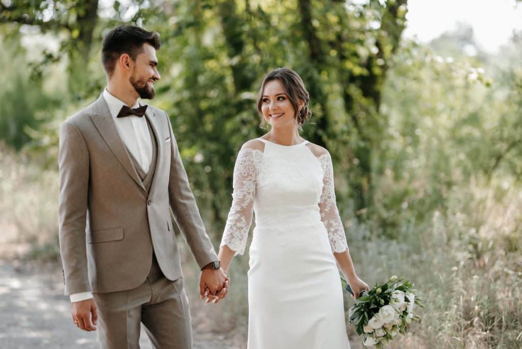 Is WeddingWire Worth It? A Guide for Wedding Venues 2 A couple gaze at each other during their wedding in the woods.
