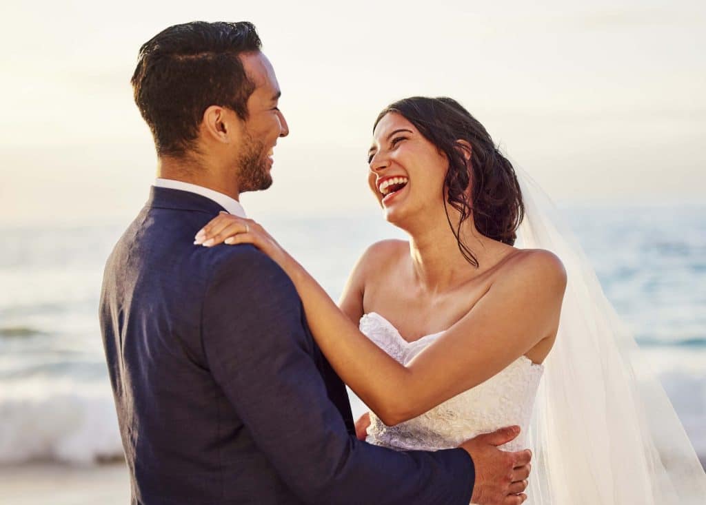 Wedding Venue Tour Questions: What High-Booking Venues Ask Differently During Tours 4 Bride and groom laughing together during golden hour after a wedding venue tour at a beachfront wedding venue